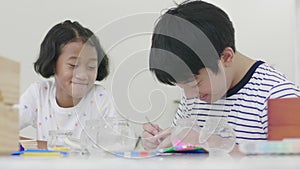 The young asian boy and girl are playing with the jigsaw puzzle with smile face.