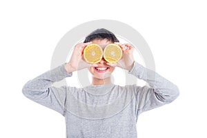 Young asian boy holding orange and smiles