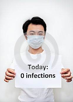 Young Asian boy holding a paper with 0 infections notice