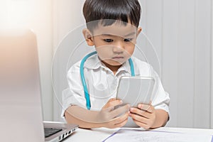 Young asian boy playing doctor and using smartphone