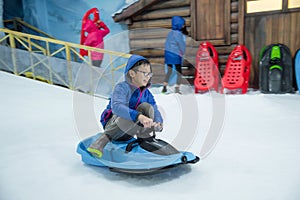 Young boy riding sleigh and smiles