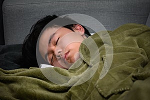 Young Asian boy sleeping tight