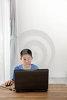Young Asian boy using laptop technology