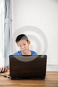 Young Asian boy using laptop technology at home. copyspace