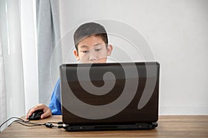Young Asian boy using laptop technology at home. copyspace