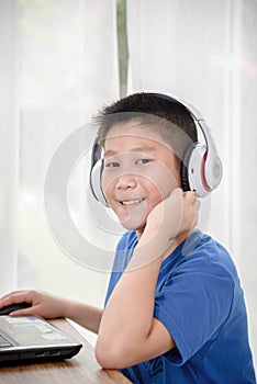 Young Asian boy using laptop technology at home. copyspace