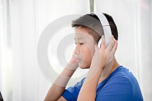 Young Asian boy using laptop technology at home. copyspace