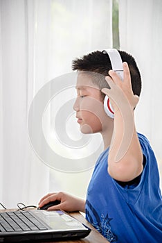 Young Asian boy using laptop technology at home. copyspace