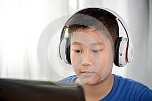 Young Asian boy using laptop technology at home. copyspace