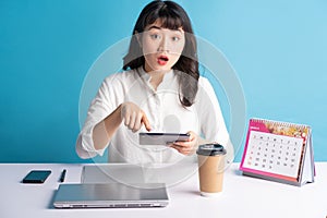 Young asian buisness woman working on blue background