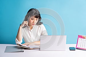 Young asian buisness woman working on blue background photo