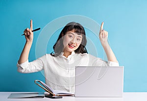 Young asian buisness woman working on blue background photo