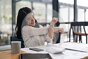 Young Asian Business Accountant woman stretching herself and relax while working hard