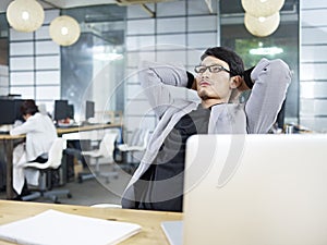 Young asian business executive thinking in office