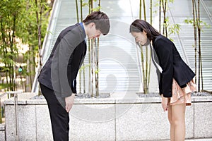 Young Asian business executives bowing to each other