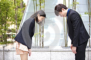 Young Asian business executives bowing to each other