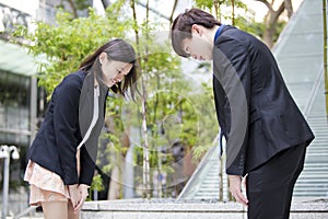 Young Asian business executives bowing to each other