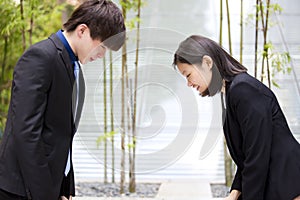 Young Asian business executives bowing to each other