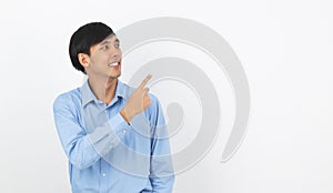 Young asian business man with blue shirt pointing to the side with a hand to present a product or an idea isolated on white