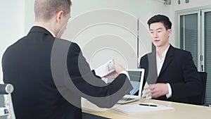 Young asian business man giving resume and information with manager for job interview
