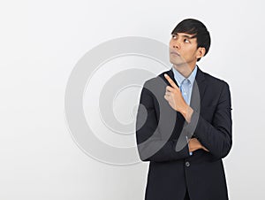 Young asian business man pointing to the side with a finger to present a product or an idea while looking forward
