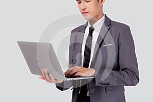 Young asian business man standing work on laptop computer to internet online isolated on white background.