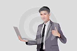 Young asian business man standing work on laptop computer to internet online isolated on white background.