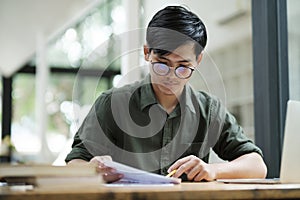 Young asian business man or student working online on computer laptop.