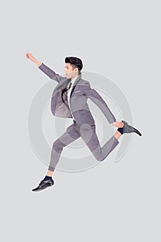 Young asian business man in suit jumping isolated on white background, full length.