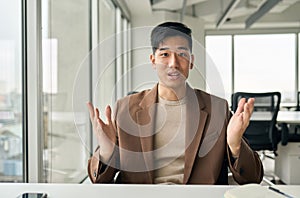 Young Asian business man talking to camera giving online class webinar training.