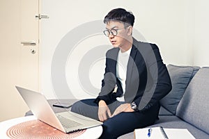Young Asian business man with using laptop computer for video conferencing while working at home. Work from home and Social