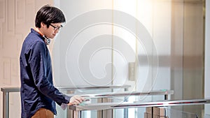 Young Asian business man using smartphone to open automatic gate