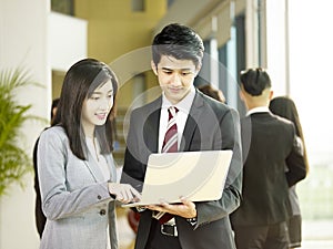 Young asian business man and woman working together in office