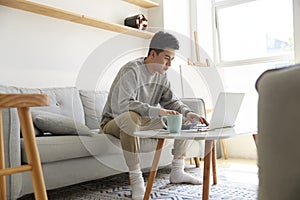 Young asian business man working at home using laptop computer