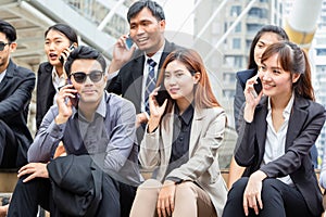 Young Asian business team discussing in the morning, Young businesspeople sitting on stairs with friends, Business people meeting