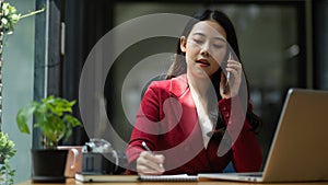 Young asian business woman having a formal business talk on the phone