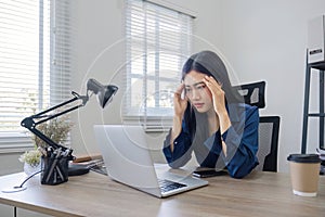 Young Asian business woman is having trouble controlling her online work in front of a laptop screen. Serious Asian