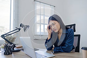 Young Asian business woman is having trouble controlling her online work in front of a laptop screen. Serious Asian