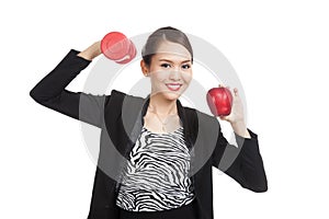 Young Asian business woman with red apple and dumbbells