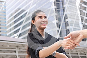 Young Asian business woman shaking hands with partners after finishing a meeting. Handshake greeting deal concept