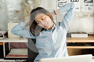 Young asian business woman sitting on the chair stretch oneself