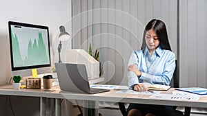 Young Asian Business woman sitting on the chair stretching herself and exercise for relaxation while working hard at office