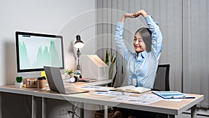 Young Asian Business woman sitting on the chair stretching herself and exercise for relaxation while working hard at office