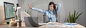 Young Asian Business woman sitting on the chair stretching herself and exercise for relaxation while working at office