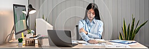 Young Asian Business woman sitting on the chair stretching herself and exercise for relaxation while working at office