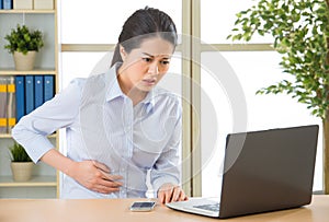 Young asian business woman with stomachache