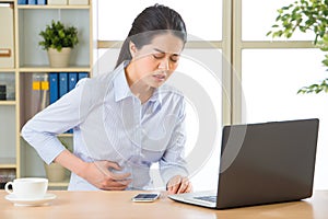 Young asian business woman with stomachache photo