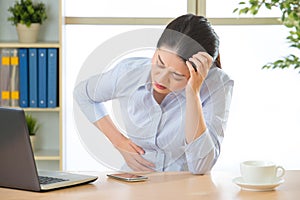 Young asian business woman with stomachache photo