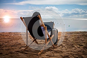 Asian business woman with tablet computer during tropical beach vacation. Freelancer working on laptop lying on sun lounger.