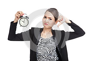 Young Asian business woman thumbs down with a clock